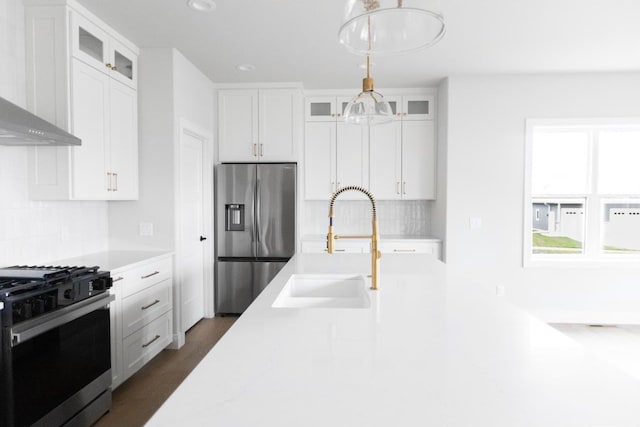 kitchen featuring white cabinetry, stainless steel appliances, and decorative light fixtures