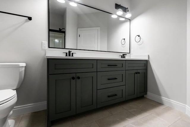 bathroom with tile patterned flooring, vanity, and toilet