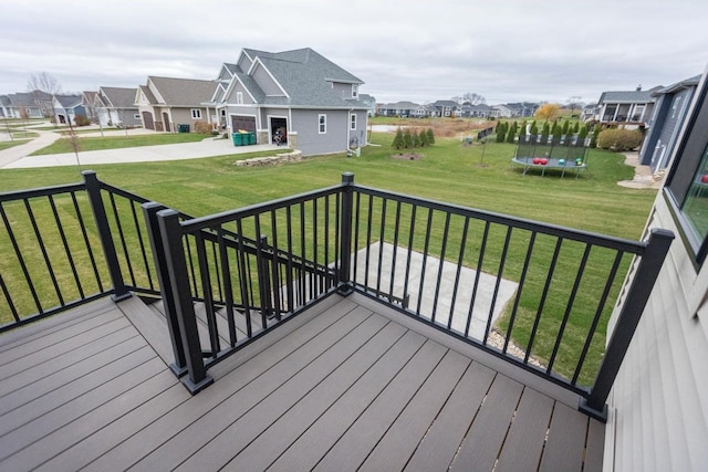 deck with a yard and a trampoline