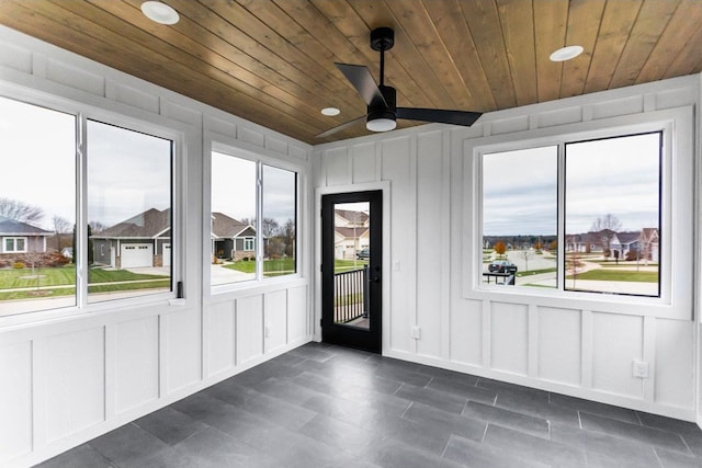 interior space featuring ceiling fan, a healthy amount of sunlight, and wooden ceiling