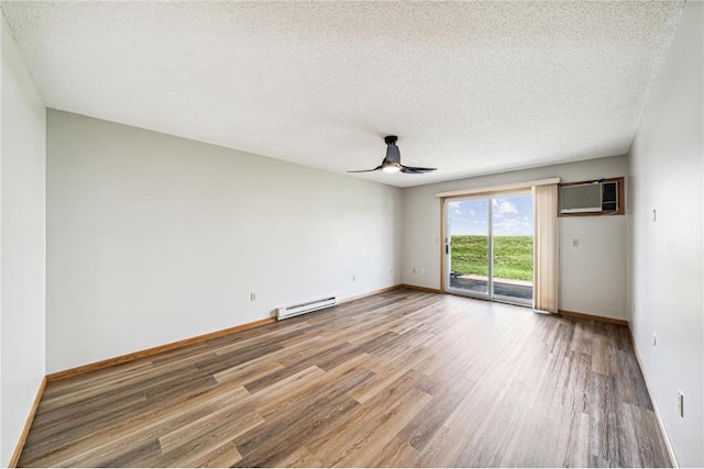 unfurnished room with a textured ceiling, a wall unit AC, ceiling fan, a baseboard radiator, and hardwood / wood-style flooring