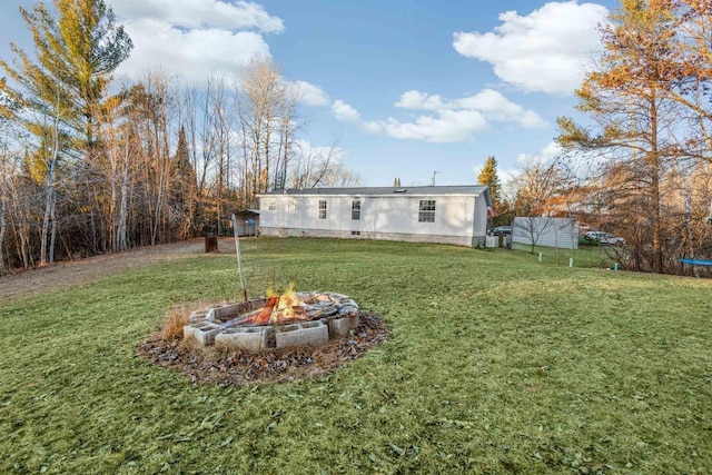 view of yard featuring a shed and a fire pit