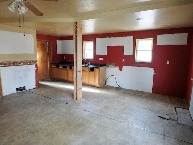 kitchen with ceiling fan, sink, and white cabinets