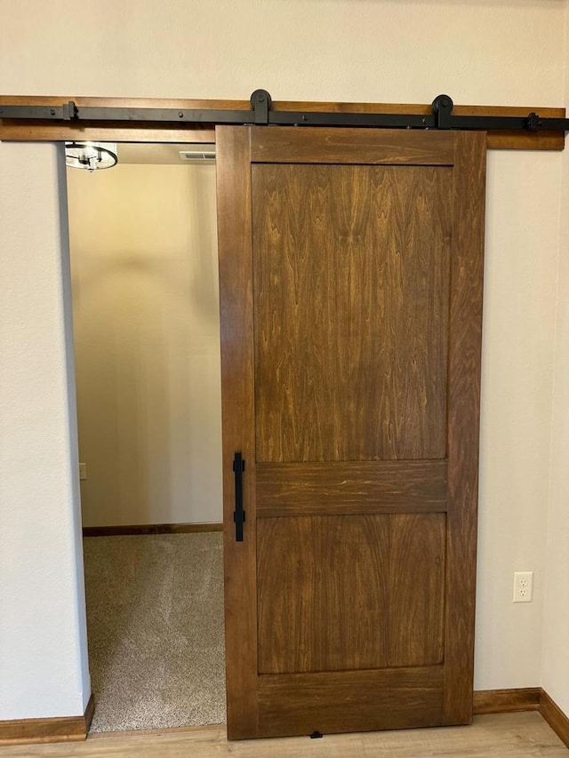 details featuring a barn door and carpet floors