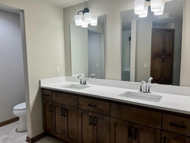 bathroom featuring tile patterned floors, vanity, a chandelier, and toilet