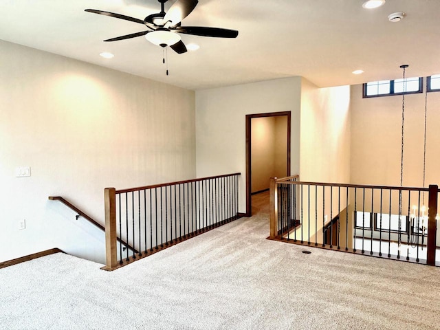 carpeted spare room featuring ceiling fan