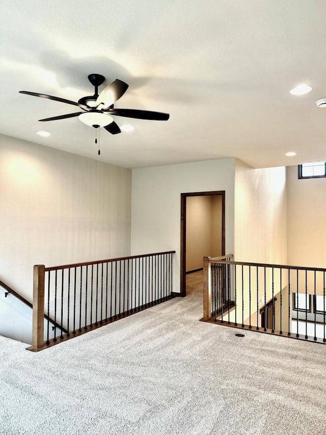 empty room with ceiling fan and light colored carpet