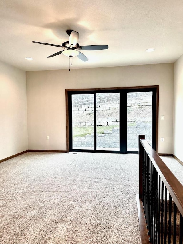 carpeted spare room featuring ceiling fan