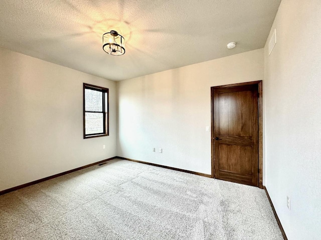 carpeted spare room with a textured ceiling