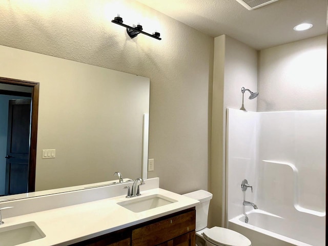 full bathroom with a textured ceiling, vanity, toilet, and tub / shower combination