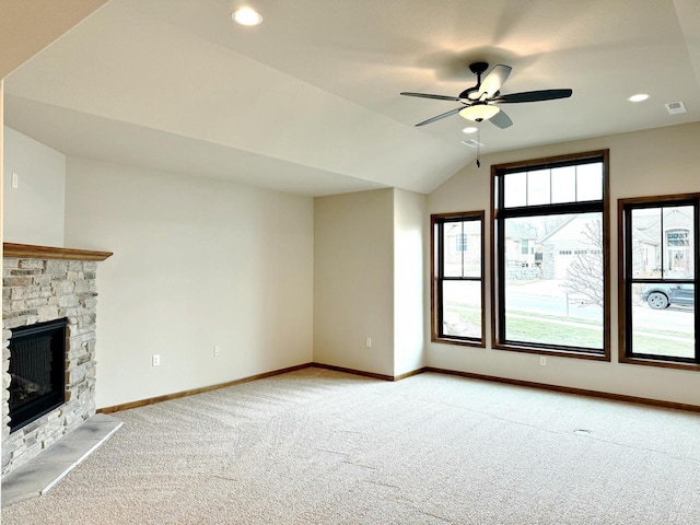 unfurnished living room featuring ceiling fan, a fireplace, light colored carpet, and lofted ceiling