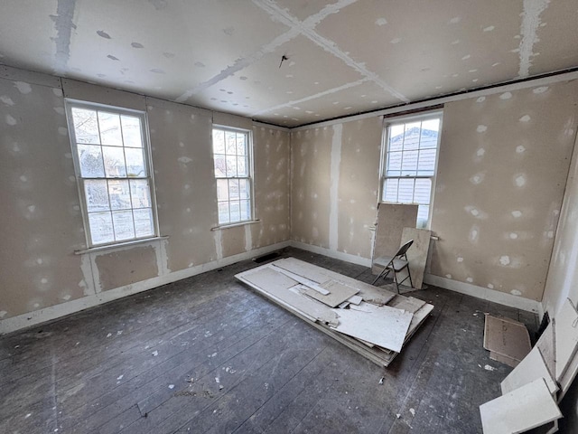 empty room with plenty of natural light and dark hardwood / wood-style flooring