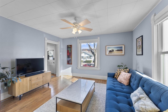 living room with light wood-type flooring and ceiling fan