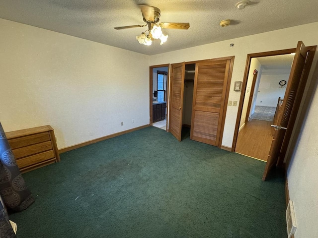 unfurnished bedroom with dark carpet, a textured ceiling, ceiling fan, and a closet