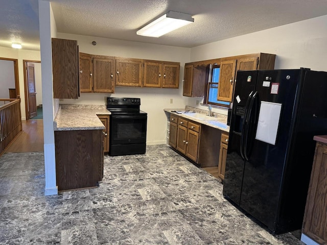 kitchen with sink, a textured ceiling, and black appliances