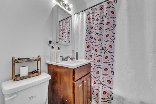 bathroom featuring vanity, toilet, and curtained shower