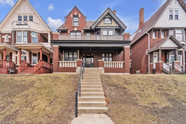 view of front facade with covered porch, a balcony, and a front lawn