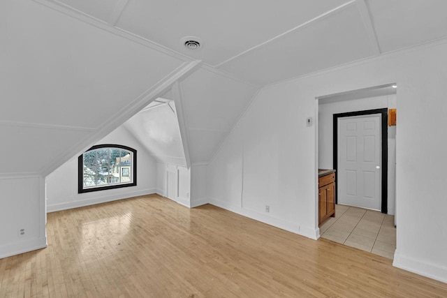 additional living space featuring light hardwood / wood-style floors and lofted ceiling