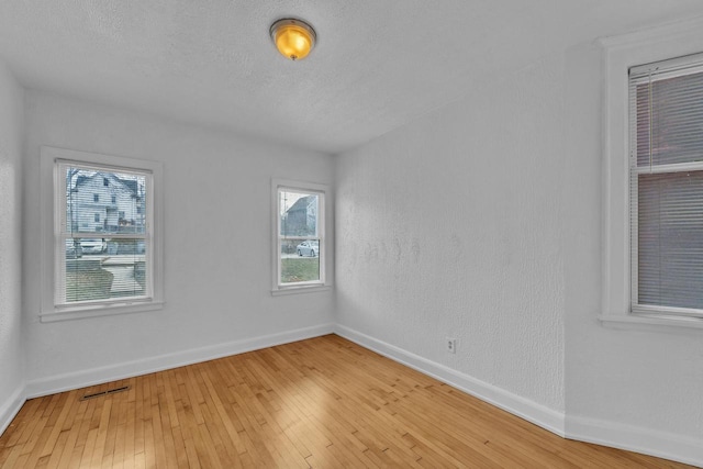 spare room featuring a textured ceiling and hardwood / wood-style flooring