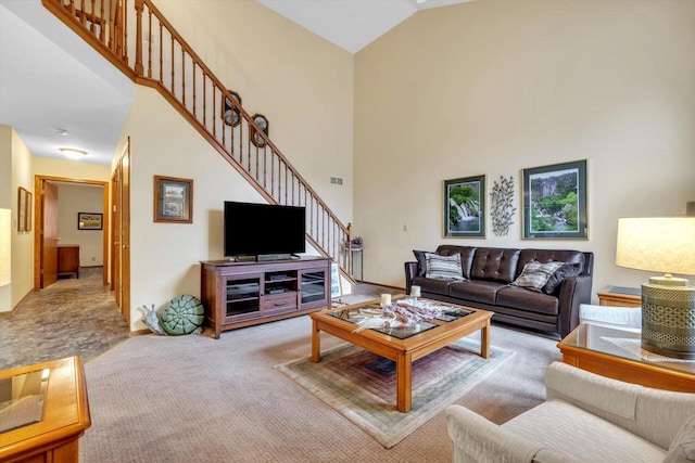 carpeted living room with high vaulted ceiling