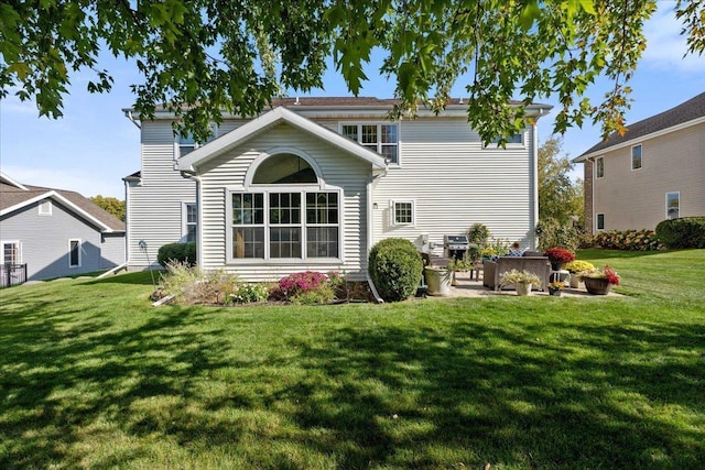 back of house featuring a patio and a yard