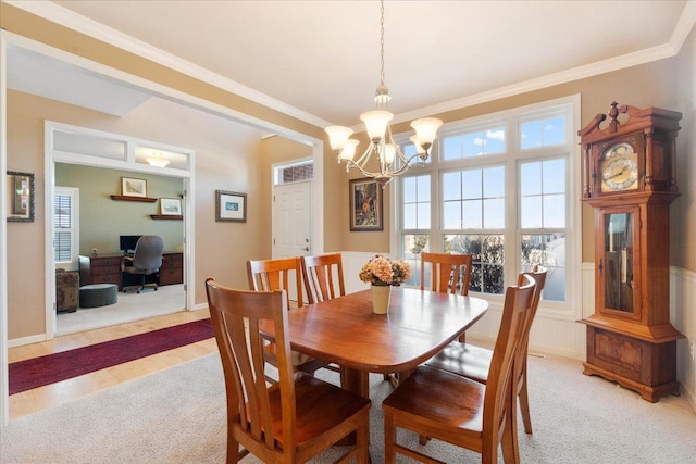 carpeted dining room featuring ornamental molding and a notable chandelier