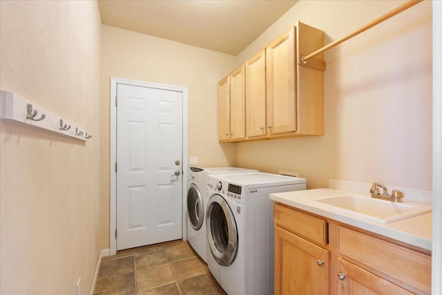 laundry area with separate washer and dryer, cabinets, and sink