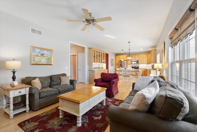 living room featuring ceiling fan and light hardwood / wood-style floors