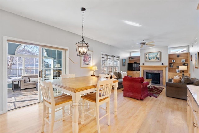 dining room featuring light wood-type flooring and ceiling fan with notable chandelier