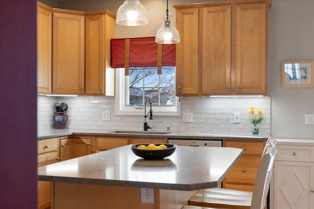 kitchen with a kitchen island, a breakfast bar area, backsplash, and sink