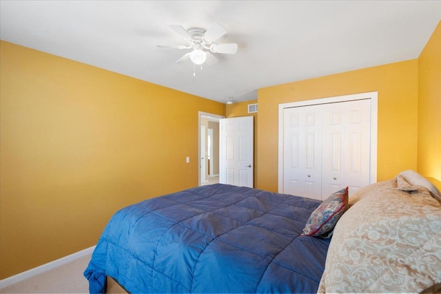 carpeted bedroom featuring ceiling fan and a closet