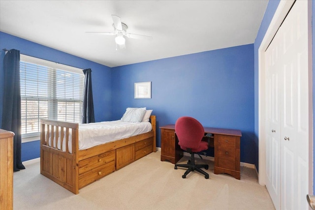 bedroom with ceiling fan, a closet, light carpet, and multiple windows