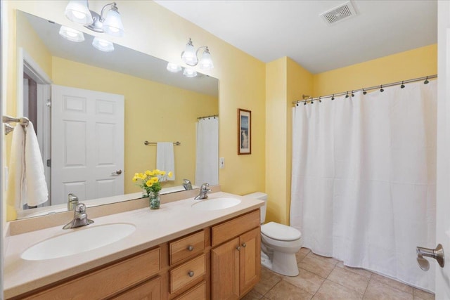 bathroom with toilet, tile patterned floors, and vanity