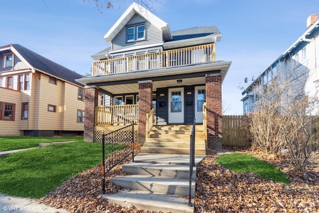 view of front of property featuring a front yard, a porch, and a balcony