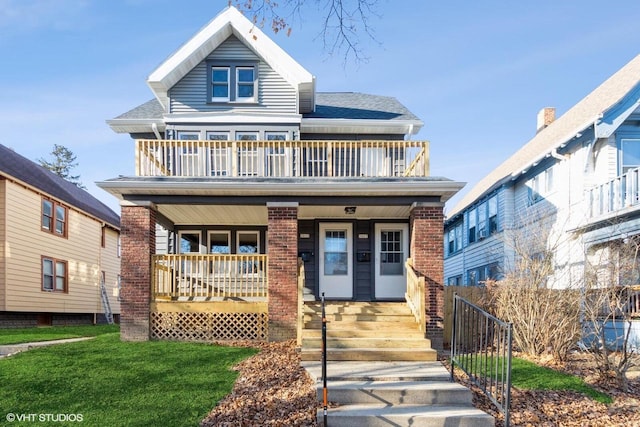 view of front of home with a front yard, a porch, and a balcony