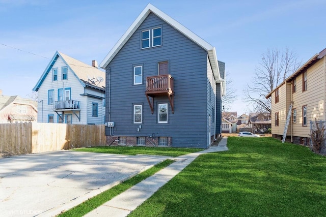 back of house featuring a yard and a balcony