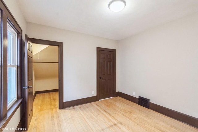 unfurnished bedroom featuring light hardwood / wood-style floors and a closet