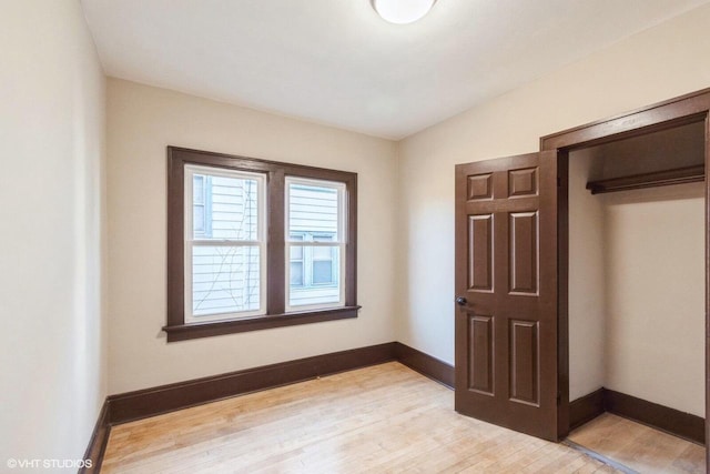 unfurnished bedroom featuring light wood-type flooring and a closet