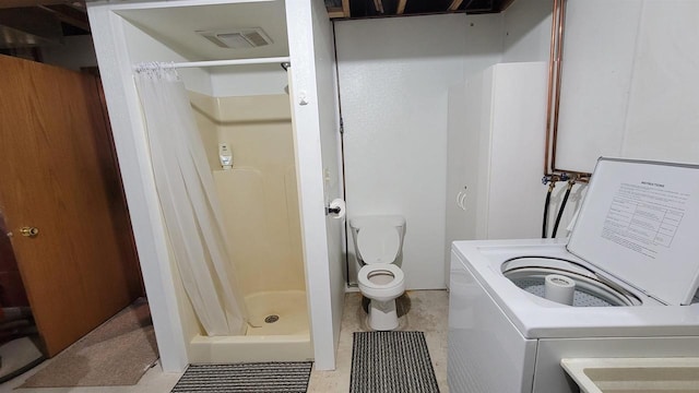 bathroom featuring washer / dryer, toilet, and walk in shower