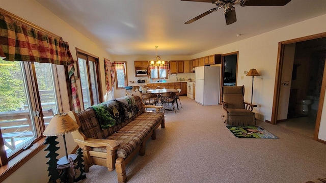 living room with light carpet and ceiling fan with notable chandelier