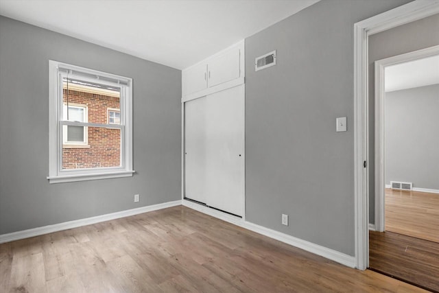 unfurnished bedroom with light wood-type flooring and a closet