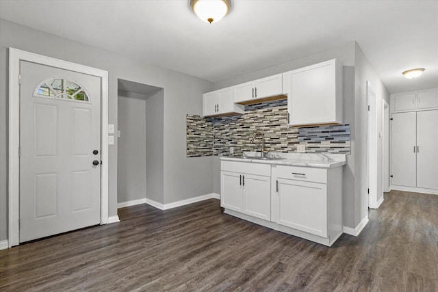 kitchen featuring decorative backsplash, white cabinetry, dark wood-type flooring, and sink