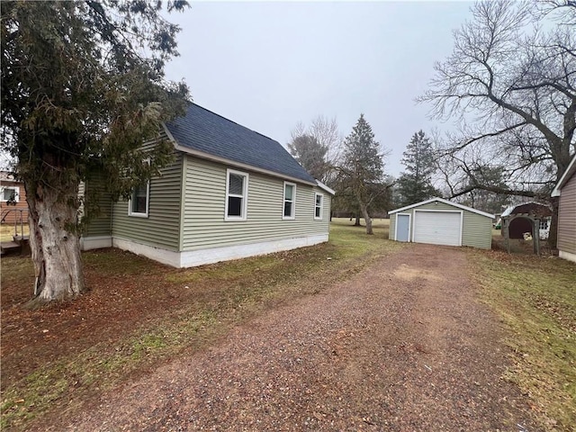 view of side of property with a garage and an outbuilding