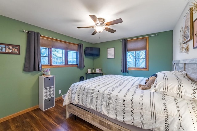 bedroom featuring multiple windows, dark hardwood / wood-style flooring, and ceiling fan