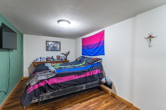 bedroom featuring hardwood / wood-style floors and a textured ceiling