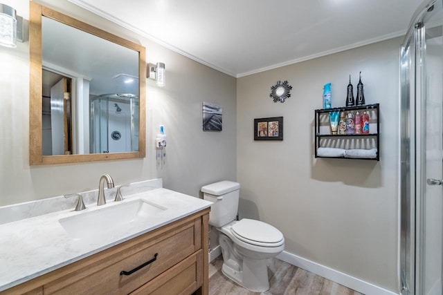 bathroom featuring toilet, vanity, wood-type flooring, and ornamental molding