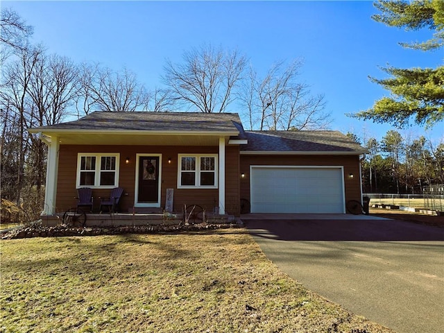 single story home with a front lawn, covered porch, and a garage