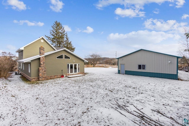 snow covered rear of property with french doors