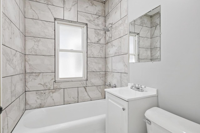 full bathroom featuring vanity, a wealth of natural light, tiled shower / bath, and toilet