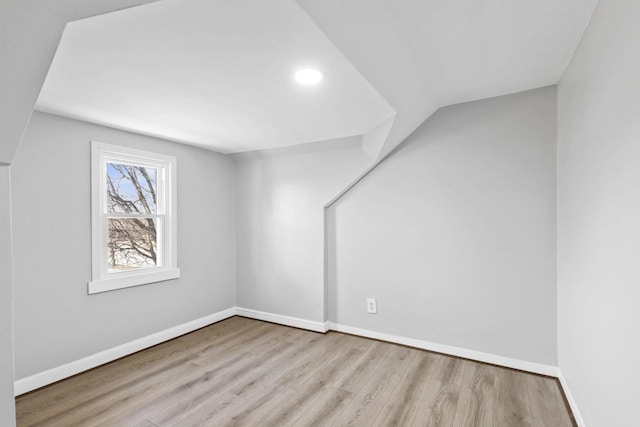 additional living space featuring lofted ceiling and light wood-type flooring